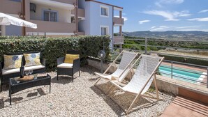 A terrace with outdoor furniture, a pool, and a view of the landscape. - Apartment Emma by Interhome (Badesi)