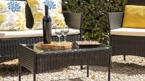 A wicker outdoor seating area with a table, wine bottle, and glasses. - Apartment Emma by Interhome (Badesi)
