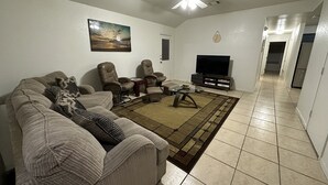A living room with a sofa, two armchairs, a coffee table, a TV, and a ceiling fan. - Zen space @ Harker Heights (Harker heigths)