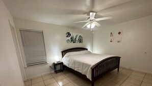 A bedroom with a bed, a ceiling fan, a bedside table with a lamp, and a window with blinds. - Zen space @ Harker Heights (Harker heigths)