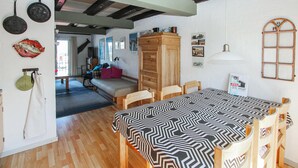 Una stanza accogliente con un tavolo da pranzo in legno, un divano e un armadio.