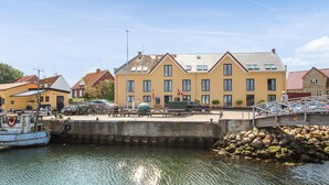 Un edificio sul lungomare con un molo, biciclette e un mucchio di pietre.