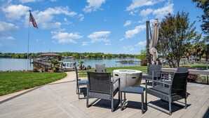 An outdoor patio with a view of a lake, a gazebo, and a dock.