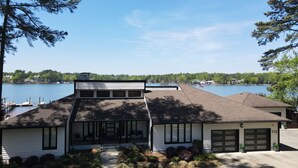 A two-story house with a garage, a dock, and a view of a lake.