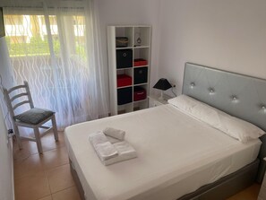2 dormitorios y tabla de planchar con plancha