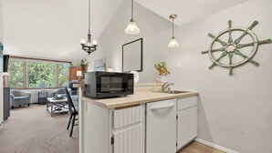A modern kitchen with a microwave, sink, and a ship's wheel decoration. - Ephraim Condo | Walk to Water, Wilson's and Shops (Ephraim)