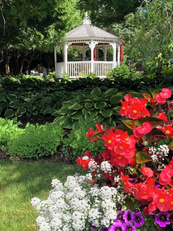 Un mirador rodeado de abundante vegetación y una variedad de flores coloridas.