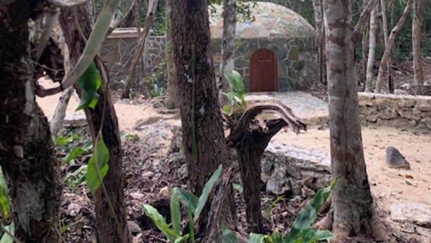 A stone building with a wooden door, surrounded by trees and a stone wall. - Remarkable Studio in jungle of Chemuyil, Tulum (Chemuyil)