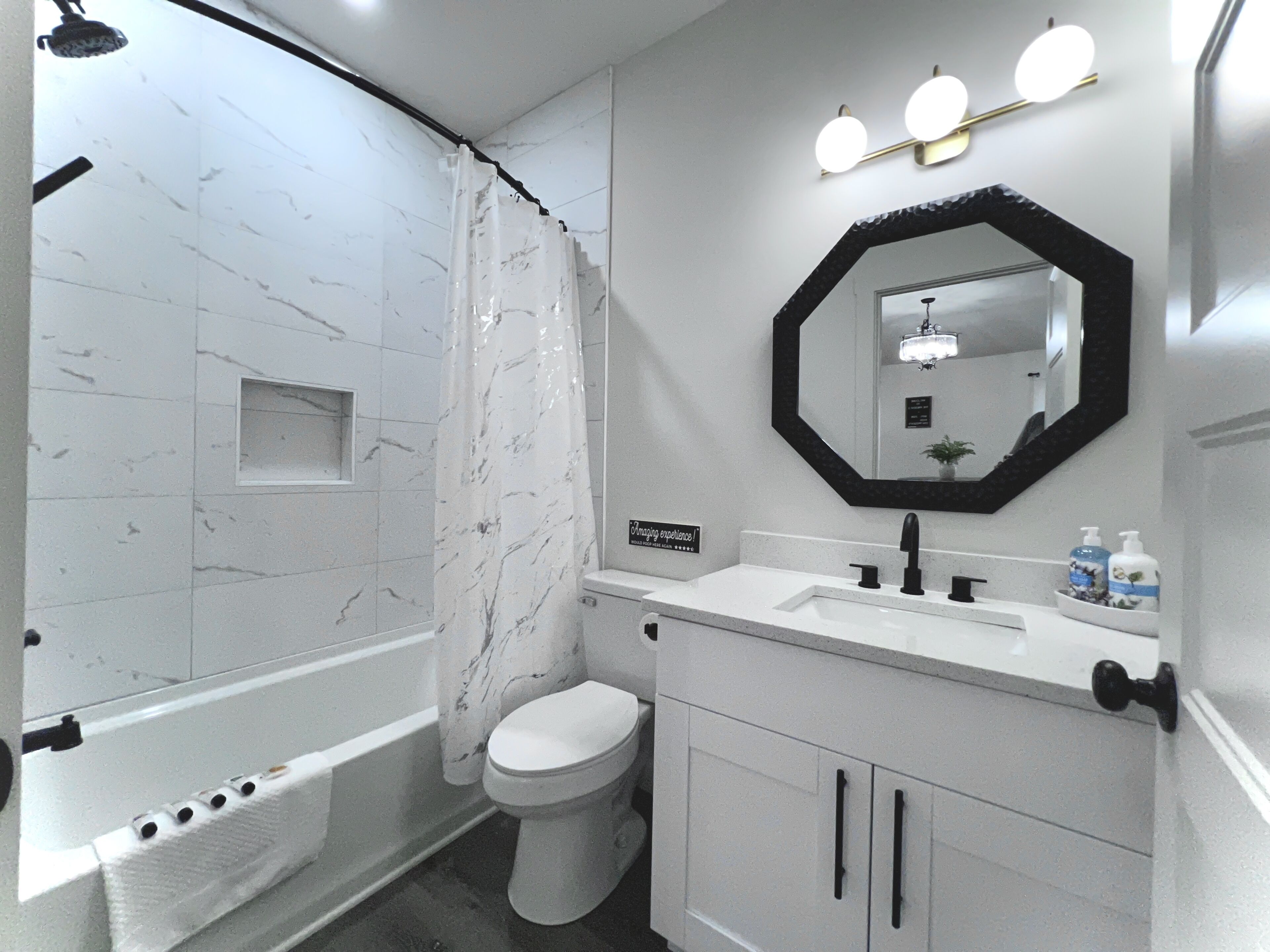 Une salle de bain avec une baignoire, des toilettes et un meuble-lavabo avec un miroir.
