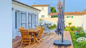 A wooden deck with a table and chairs, an umbrella, and a bicycle in the background. - 3 bedroom nice home in Les Portes-en-Ré (Les Portes-en-Ré)