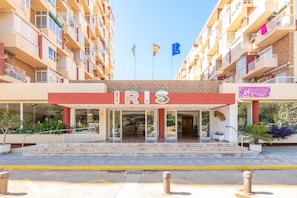 A hotel entrance with a red awning labeled 'IRIS,' multiple balconies, and flags. - RENTHAS Studio in Benalmádena (Benalmadena)