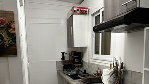 Uma cozinha compacta com micro-ondas, fogão e armários.