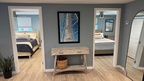 A bedroom with a bed, a bedside table, a framed picture, and a potted plant. - Beach house - 3 min walk to beach! (Englewood)