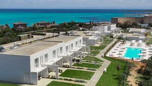 A resort with modern architecture, a swimming pool, and a view of the ocean. - Capo Falcone B. Premium, Stintino, Italy (Stintino)