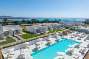 A pool area with lounge chairs and umbrellas, a clear blue pool, and a view of the sea. - Capo Falcone Bilo Premium, Stintino, Italy (Stintino)