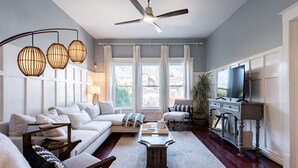 A modern living room with a sofa, coffee table, and TV stand.
