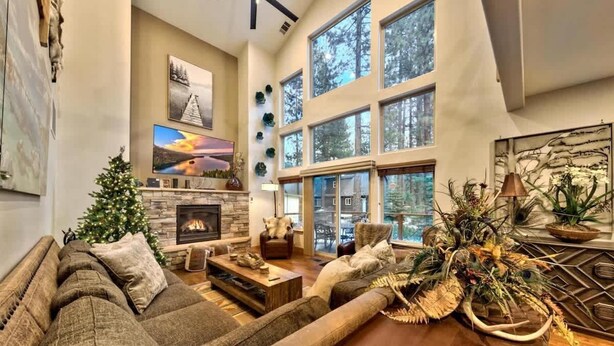 A spacious living room with a fireplace, large windows, and a cozy seating area.