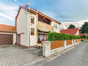 A two-story residential building with a garage, a balcony, and a brick wall. - Apartment Lisa by Interhome (Balatonmariafurdo)