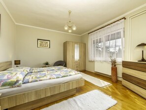 A bedroom with a bed, a wardrobe, a desk, a chair, a lamp, and a window with curtains. - Apartment Lisa by Interhome (Balatonmariafurdo)
