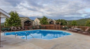 Relax by the resort's central pool surrounded by lounge chairs and a wooden deck.