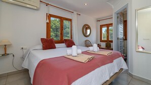 A hotel room with a large bed, a bedside table with a lamp, a mirror on the wall, and a window with curtains. - Puravida - Javea, Costa Blanca (Javea)