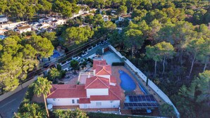 An aerial view of a residential area with a house featuring a red-tiled roof, a swimming pool, and solar panels. - Vacation home Johlim by Interhome (Moraira)