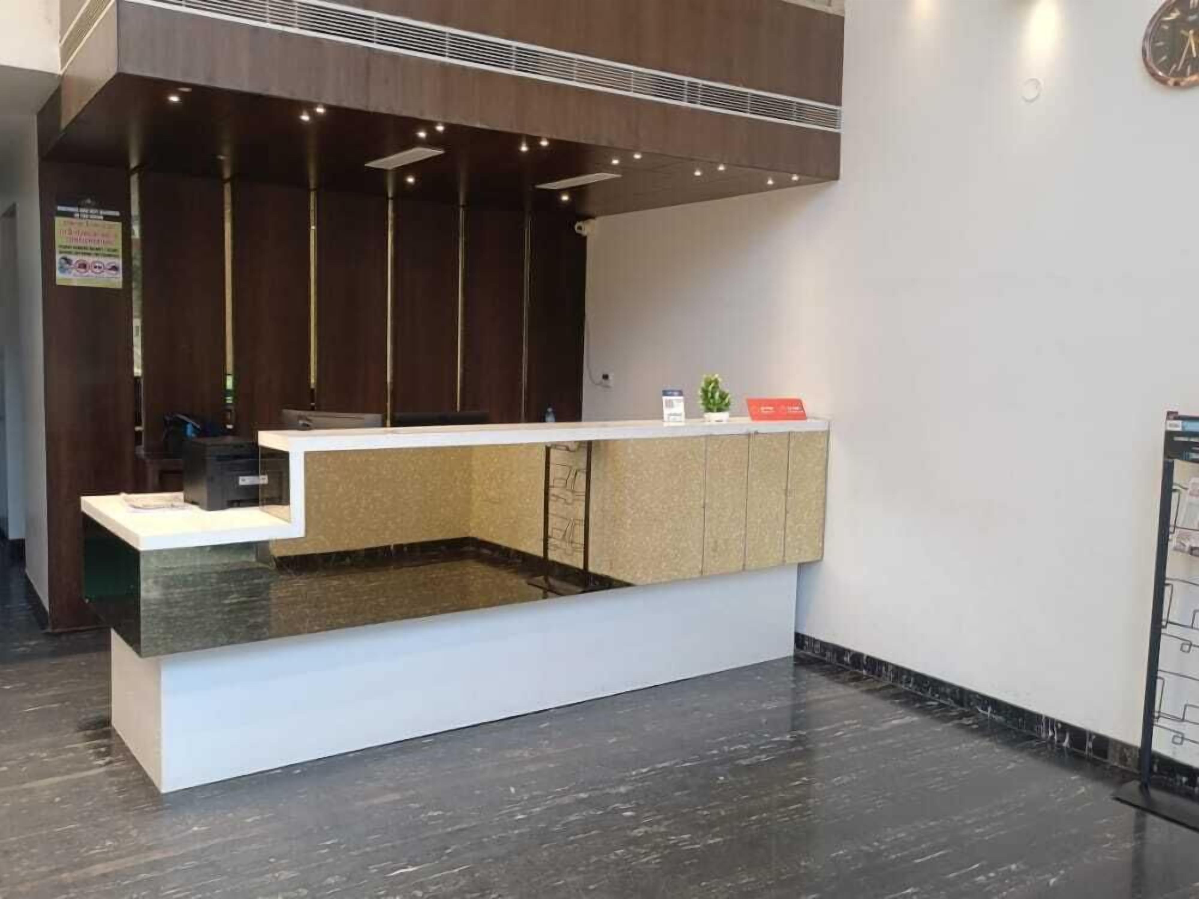 Una recepción con diseño moderno, que presenta un mostrador blanco y una zona hundida.