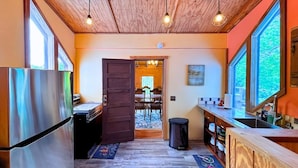 A compact kitchen with a wooden ceiling, a stainless steel refrigerator, and a dining area visible through an open door. - Secluded Estate Sleeps 8 with 1 acre fishing pond  (Mount Pleasant)