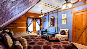 A bedroom with a sloped ceiling, a bed with patterned bedding, a desk, a chair, and a wardrobe. - Secluded Estate Sleeps 8 with 1 acre fishing pond  (Mount Pleasant)