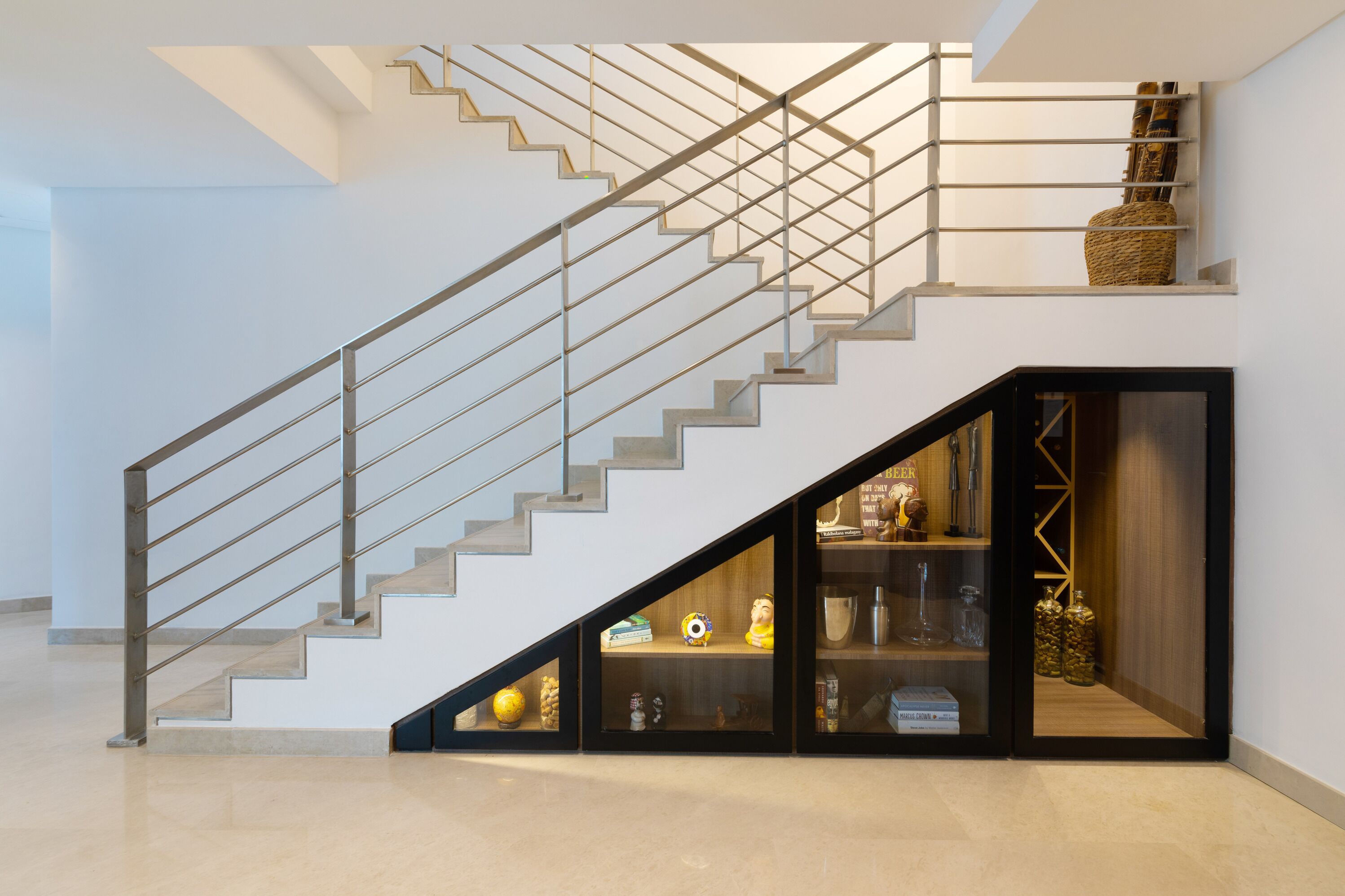 A modern staircase with a glass enclosure leading to a lower level.