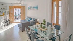 A modern living room with a glass dining table, grey sofa, and a ceiling fan. - Pont del Moncau by Interhome (Altea)