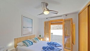 A hotel room with a bed, a ceiling fan, a window with wooden shutters, and a painting on the wall. - Pont del Moncau by Interhome (Altea)