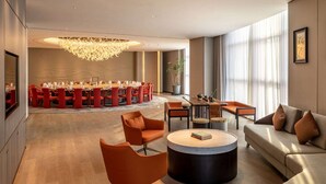 A modern hotel lobby with a dining area, seating arrangements, and a large chandelier. - Wyndham Grand Plaza Royale Yujia Anhua (Yiyang)