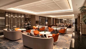 A spacious lobby with modern seating arrangements, a high ceiling with recessed lighting, and a polished floor. - Wyndham Grand Plaza Royale Yujia Anhua (Yiyang)