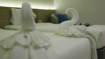 Neatly made white towels on hotel beds.