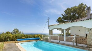 A swimming pool with a wooden deck, a covered seating area, and a view of the sea. - Can Delmas by Interhome (Pals)