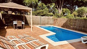 A swimming pool with lounge chairs and a covered seating area. - La Victoria by Interhome (Palafrugell)