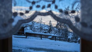 A snowy landscape with a wooden fence and snow-covered trees.