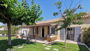A house with a patio, outdoor furniture, and a garden with stepping stones. - Villa Art-Déco, 5 mn walk from the city center of Saint-Rémy- Pool, Clim - 4ps (Saint-Rémy-de-Provence)