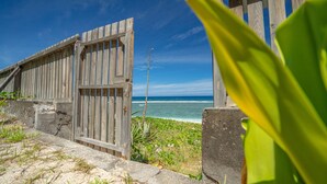 A wooden gate leading to a beach with a clear view of the ocean. - ST GILLES, CHARMING HOUSE, seaside, Coral villa, lagoon, 4 **** (Saint Paul)