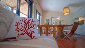 A modern hotel room with a large bed, a wooden dining table, and a view of the kitchen. - ST GILLES, CHARMING HOUSE, seaside, Coral villa, lagoon, 4 **** (Saint Paul)