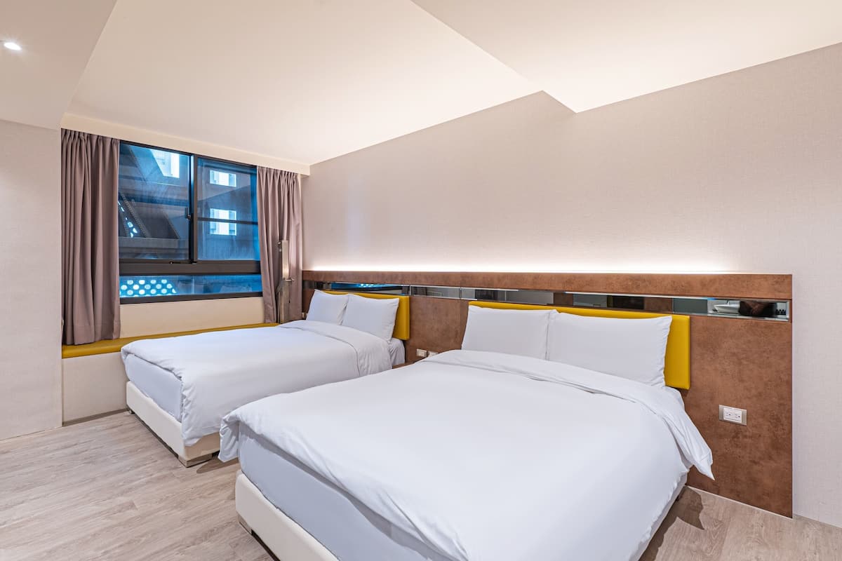 A hotel room with two beds, a large window with curtains, and a modern design.