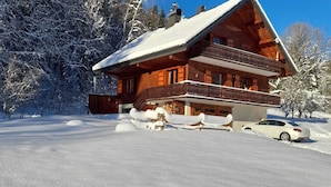A wooden chalet with a balcony, surrounded by snow-covered trees. - Quiet chalet in Abondance, 4 bedrooms, fireplace (Abondance)