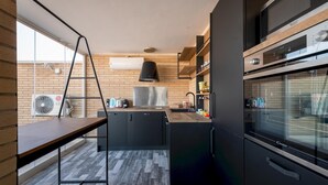 A modern kitchen with a wooden countertop, black cabinets, and a built-in oven.