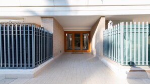 A building entrance with a tiled floor, a wooden door, and metal gates on either side. - Casa Titty in Roma With 1 Bedrooms and 1 Bathrooms (Rome)