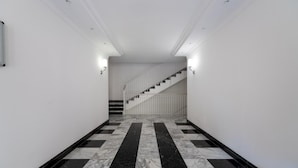 A hallway with a marble floor, white walls, and a staircase with a white railing. - Casa Titty in Roma With 1 Bedrooms and 1 Bathrooms (Rome)