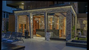 A modern building with a reception area, lounge chairs, and a stone facade.