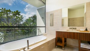 A modern bathroom with a large bathtub, a wooden vanity, and a large mirror. - Abogo Resort Villas Beachview Da Nang   (Da Nang)