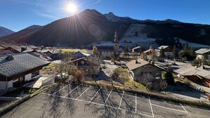 Une ville de montagne avec une église, un parking et des bâtiments aux toits inclinés.