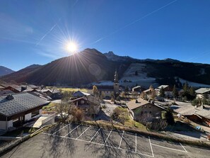 A mountain town with a church, a parking lot, and buildings with sloped roofs.